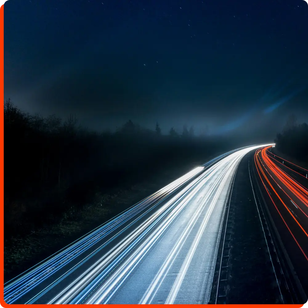 Lichtspuren mehrerer Autos auf einer Autobahn bei Nacht, symbolisch für die Geschwindigkeit und Effizienz von Besetzungen von Mitarbeitern.