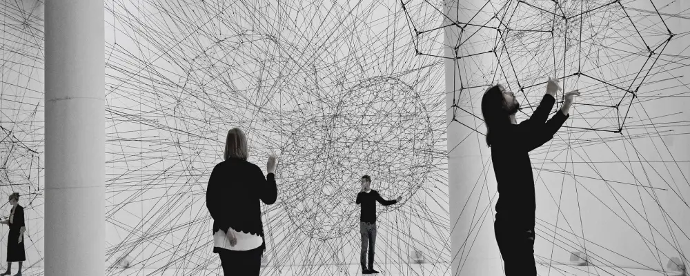 Menschen berühren geometrische Formen, die aus Netzen bestehen, symbolisch in einer innovative Umgebung arbeiten.