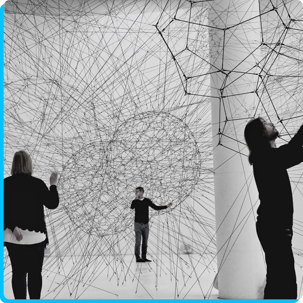 Menschen berühren geometrische Formen, die aus Netzen bestehen, symbolisch in einer innovative Umgebung arbeiten.