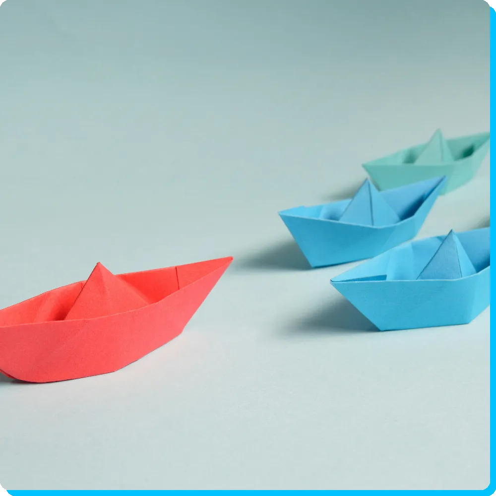 Team Rotes Papierschiff, gefolgt von blauen Papierschiffen, symbolisiert das Team von RIVNA Partners